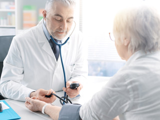 Doctor measuring blood pressure of a senior patient