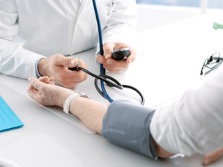 Doctor measuring blood pressure of a senior patient