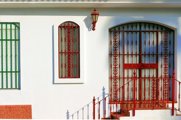 Andalusian house facade with wrought iron bars on door and window