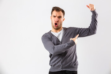 Handsome young business man over wall wearing elegant shirt showing arms muscles smiling proud. Fitness concept.