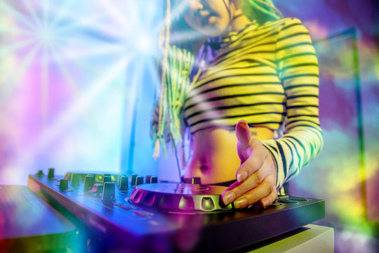 Asian girl DJ is playing a turntable in night party is colorful.