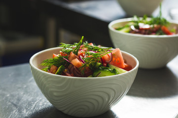Shot of a deep plate full of salad with tomato and cucumbers