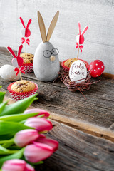 Fröhlicher Osterhase mit Blumen und Muffins