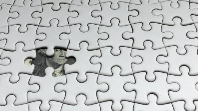 Jigsaw Puzzle piece put into missing places with Dollar money background, Succeed in Business concept, Debt settlement concept.