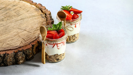 Sweet dessert in glass with biscuit, berry fruit and whipped cream. Copy space. Healthy homemade dessert