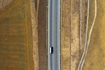 Aerial top view of cars and trucks passing on a highway