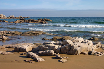 Fototapeta na wymiar Rocky reefs framing sand beach
