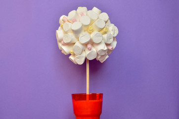 Tree made of marshmallows on vibrant violet background. Copy space.