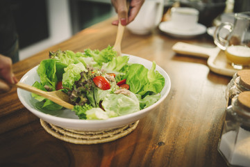 man makes a salad in the morning in the kitchen
