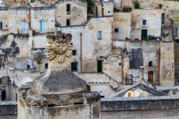 Summer day high-angle scenery street view of an artistic chimney decoration over the amazing ancient town of the Sassi with blurred background of pattern of buildings in Matera, Basilicata, Italy