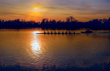 Silhouette of row boat against sunset on the lake