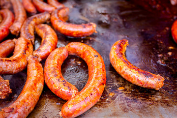 Baking delicious juicy sausages on barbecue plate