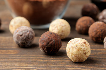 assorted chocolates. candy balls of different types of chocolate on a brown wooden table. close-up