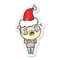 distressed sticker cartoon of a bearded man crying wearing santa hat