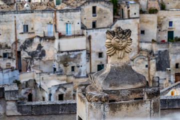 Fototapeta na wymiar Summer day high-angle scenery street view of an artistic chimney decoration over the amazing ancient town of the Sassi with blurred background of pattern of buildings in Matera, Basilicata, Italy