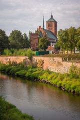 Fototapeta na wymiar Basilica of St. Catherine and Pasleka river in Braniewo, Warminsko-Mazurskie, Poland