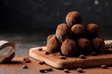 assorted chocolates. candy balls of different types of chocolate on a dark background. cocoa and...