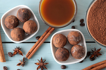 assorted chocolates. candy balls of different types of chocolate on a blue wooden table. cocoa, cinnamon, star anise and coffee beans. top view