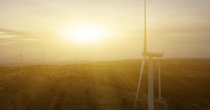 Aerial shot of wind farm turbines at sunrise