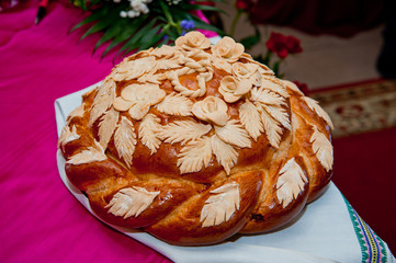Traditional Slavic wedding loaf with salt lying on a rushnik