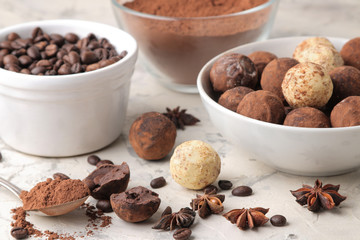assorted chocolates. Candy balls of different types of chocolate on a light concrete background. cocoa, star anise and coffee beans