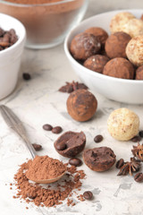 assorted chocolates. Candy balls of different types of chocolate on a light concrete background. cocoa, star anise and coffee beans