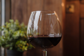 Glass of red wine on wooden table. Copy space