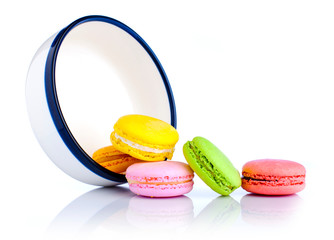 Colorful macaroons spilled from white porcelain bowl