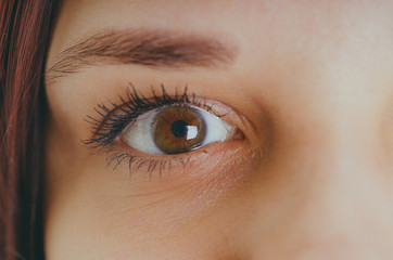 Obraz premium Women's eyes without makeup and makeup, with a lens on the eyeball. Photo eyes macro