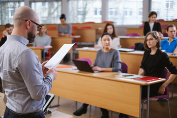 Lecturer and multinational group of students in an auditorium