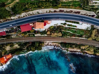 Aerial view of road, highway and railway going along ocean or sea. Drone photography in rural Italy