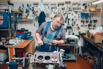 Man repairing car engine in workshop