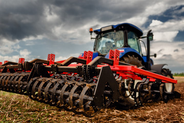 Tractor preparing land for sowing out in the field