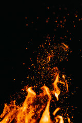 Fototapeta na wymiar Flame of fire with sparks in the air over a dark night