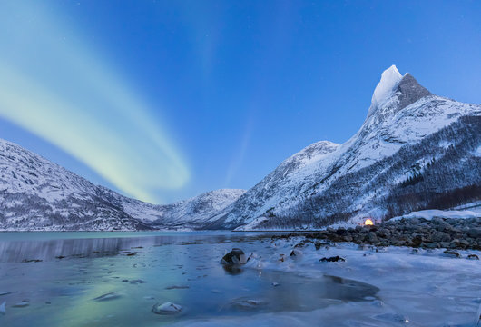 Northern lights over frozen sea in a Tysfjord bay and near the Norway's national mountains granitic snowy peak called Stetind,tysfjord Nordland county Norway Europe