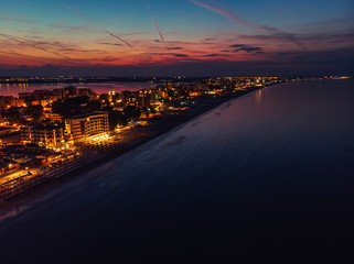 Fototapeta premium Drone bird's eye view photo of famous resort of Mamaia as seen at night with dazzling lights and waves