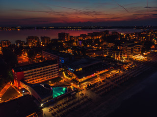 Drone bird's eye view photo of famous resort of Mamaia as seen at night with dazzling lights and waves