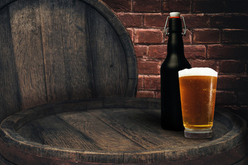Wooden barrel and glass of beer on a old oak table of wood.