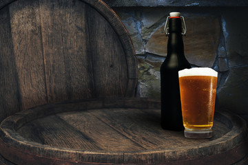 Wooden barrel and glass of beer on a old oak table of wood.