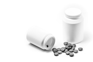 Two white pill bottle isolated on white background with dark pills