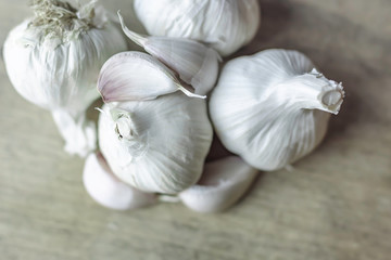 Garlic bulbs and cloves on wooden background.