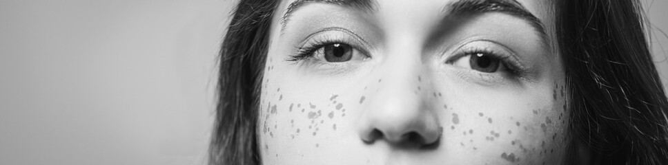 Young woman eyes. Natural youth beauty. Sparkles on cheeks fashion trend. Black and white.