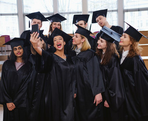 Multi ethnic group of graduated students taking selfie