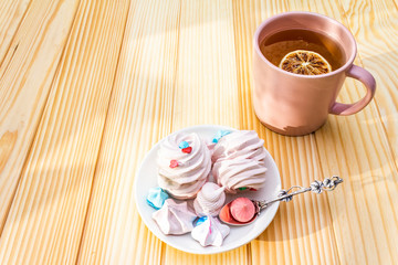 Romantic sweet breakfast concept. Green tea, lemon, meringue (cake). On wooden background.