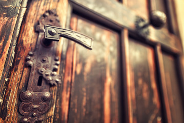 Detail of antique brown wooden door with metal handles