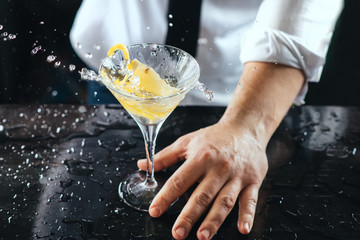 Expert barman making cocktail at nightclub. Bartender preparing cocktail at the bar. Preparing of...