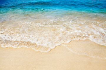 Sandy beach. Splashing waves on the seashore. Summer.
