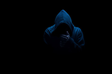 Man in black hood in the night darkness, dimly lit, concepts of danger, crime, terror - obrazy, fototapety, plakaty