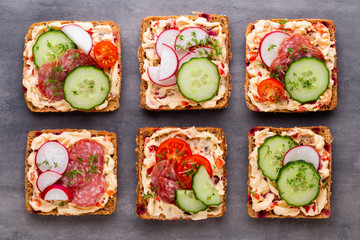 Sandwiches with cream cheese, vegetables and salami.
