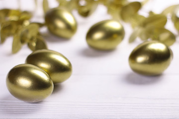 Golden egg on white vintage wooden background.